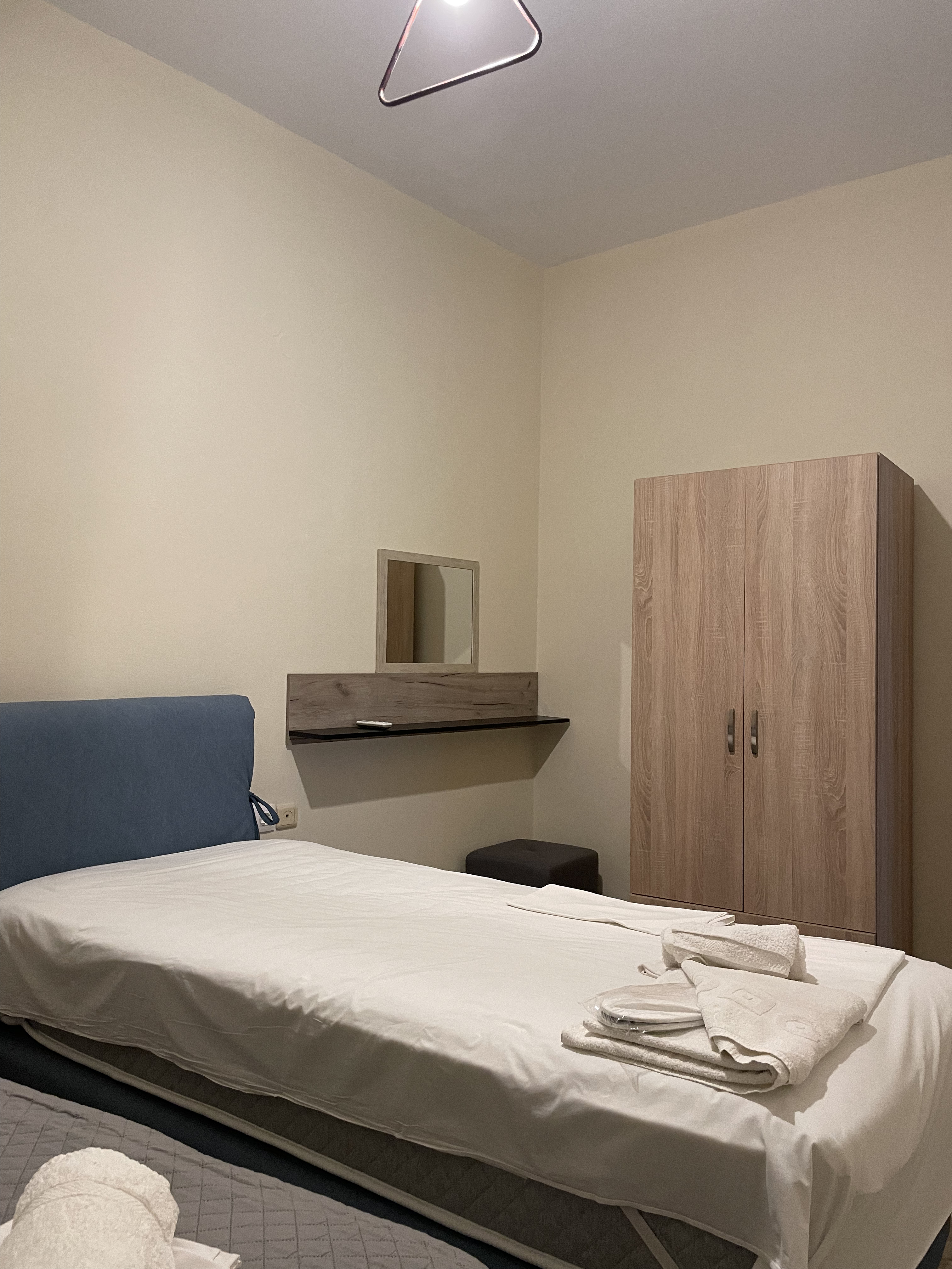 Bedroom with blue headboard and pendant light