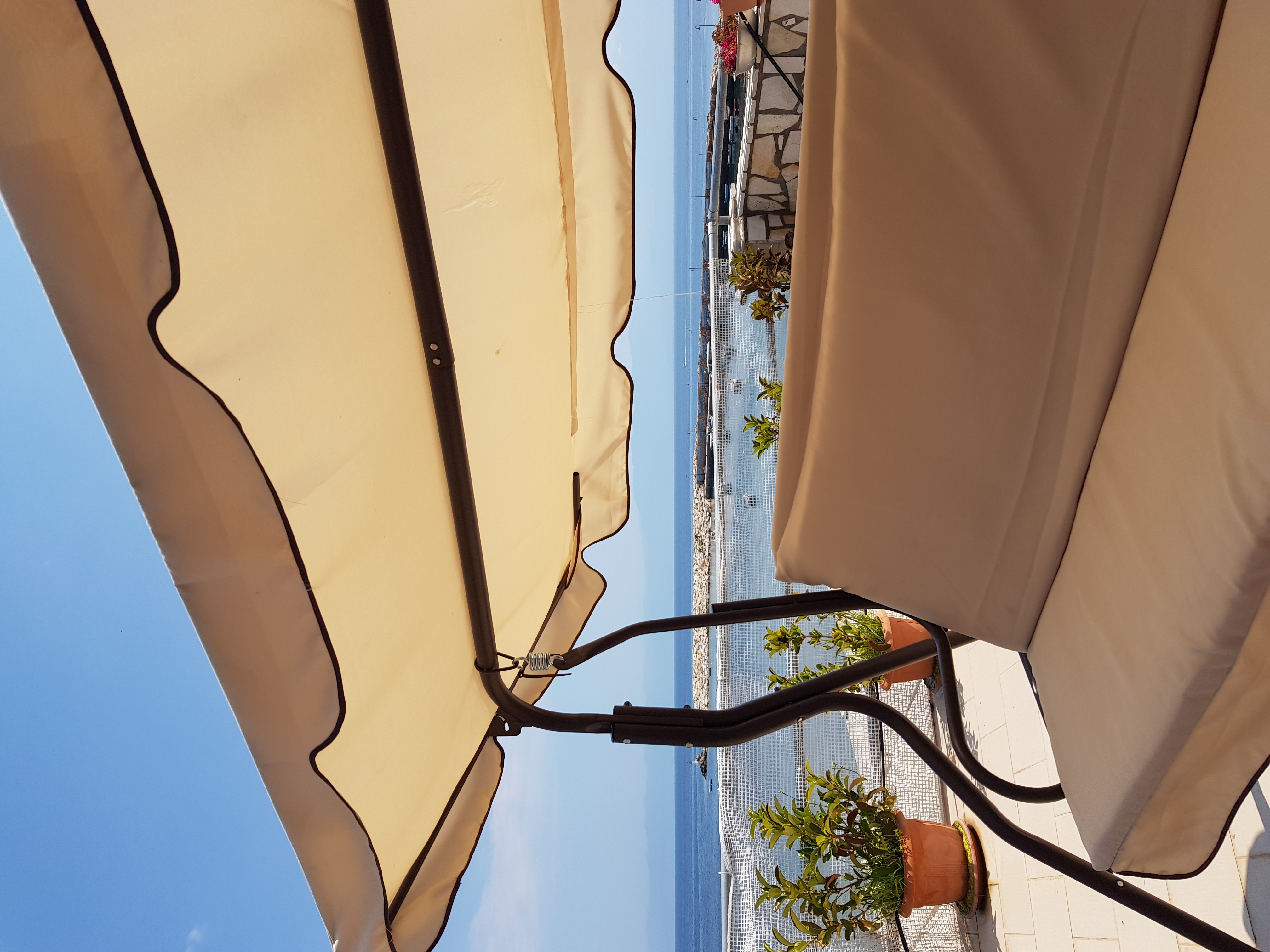 Swing seat on the summer terrace with harbour and sea