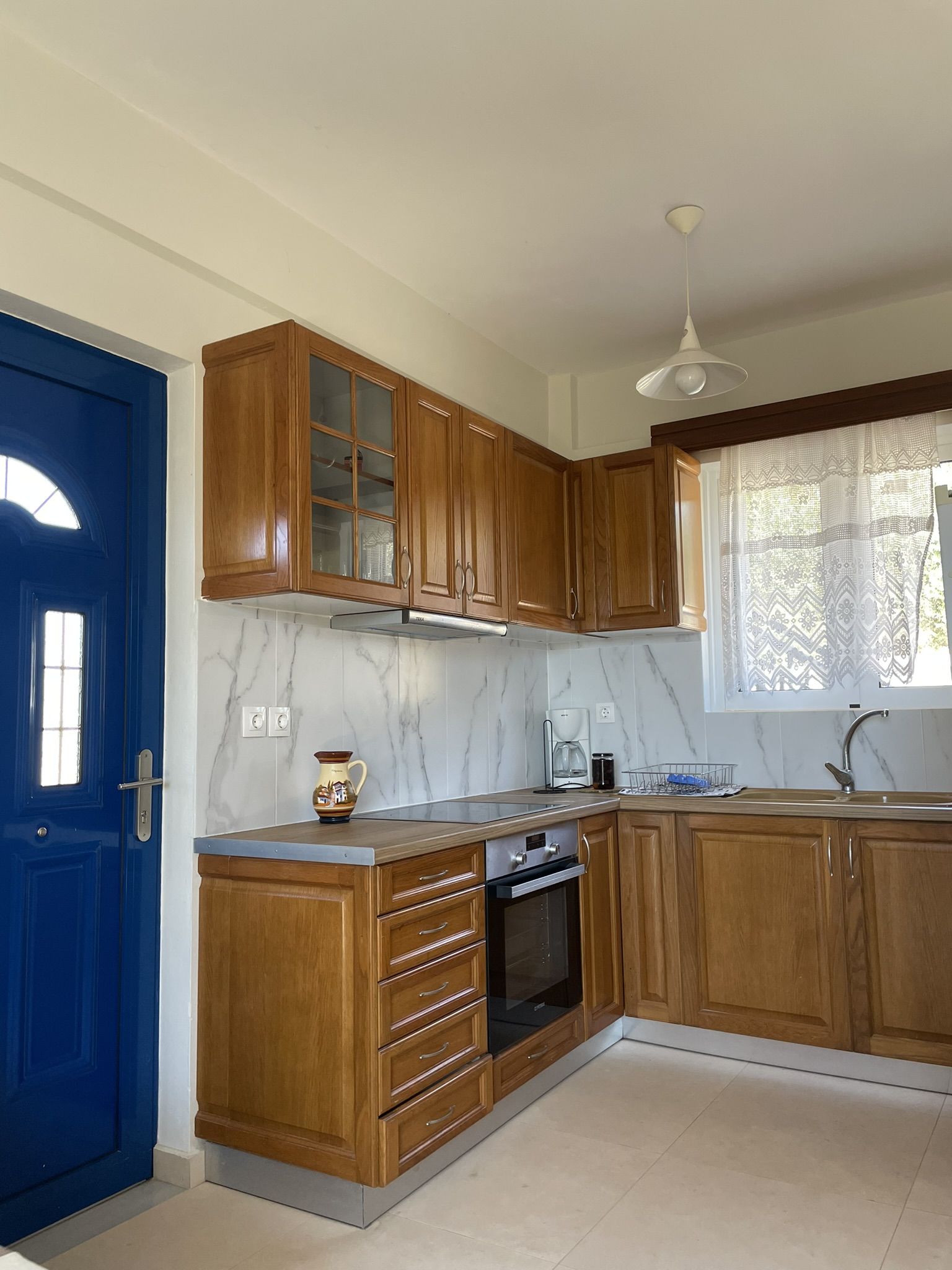 Kitchen with warm wood cabinets and blue door