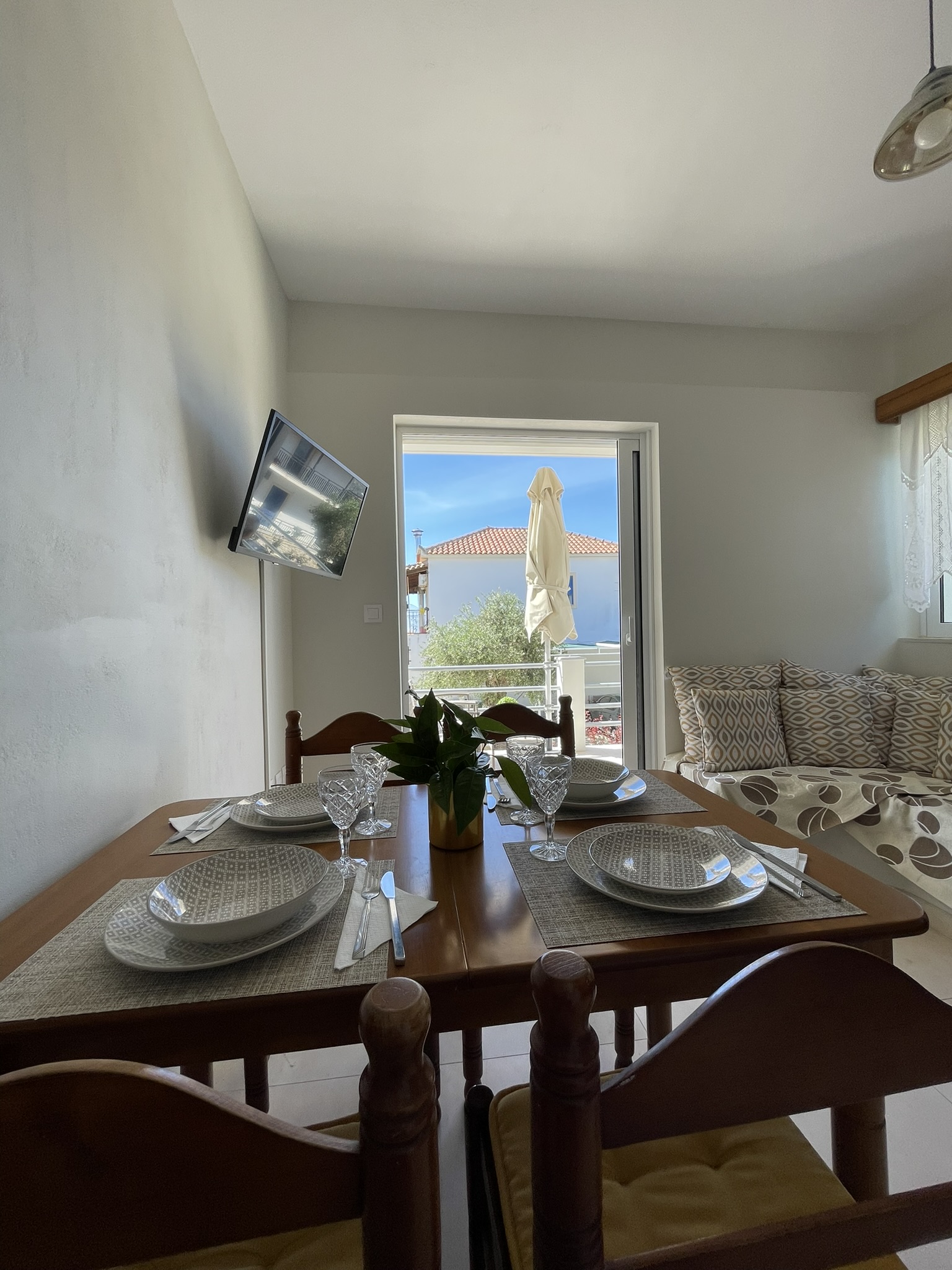 Dining table set for two with balcony view beyond